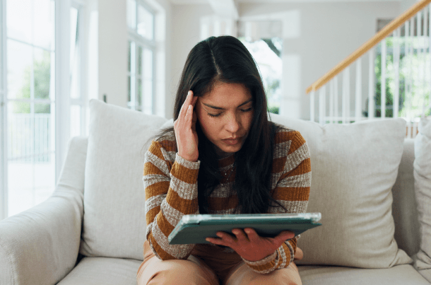 A woman reviewing information on her tablet at home, considering her next steps after a life insurance application is declined.