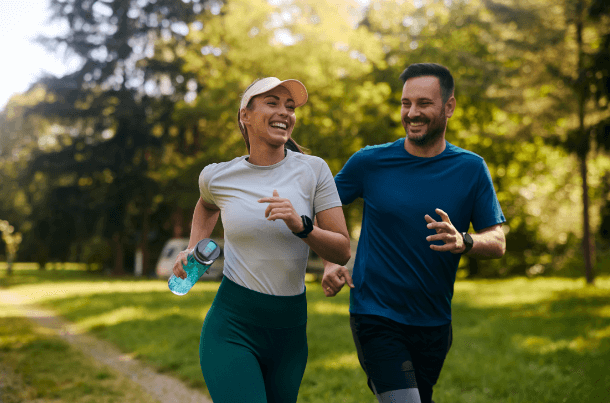Husband and wife running side by side outdoors, reflecting the shared commitment and financial protection offered through USBA&rsquo;s TWO for ONE Group Level Term Life Insurance.