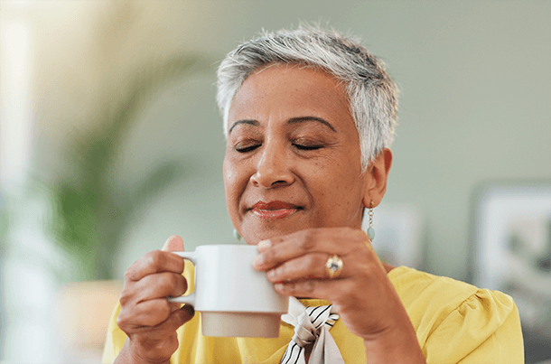 A woman enjoys her morning coffee, reflecting on how small daily choices-like life insurance with USBA-can bring long-term peace of mind.