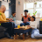 Family members laugh and play a game together in their living room, reflecting the loved ones military and federal families work to protect through life insurance.