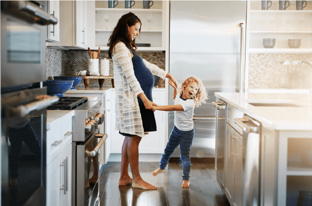 Pregnant mother and child sharing a joyful moment at home, reflecting family priorities and future planning.