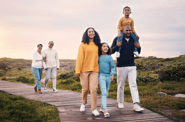 Family walking together outdoors at sunset, an insured military or federal household focused on life insurance planning and long-term financial protection.