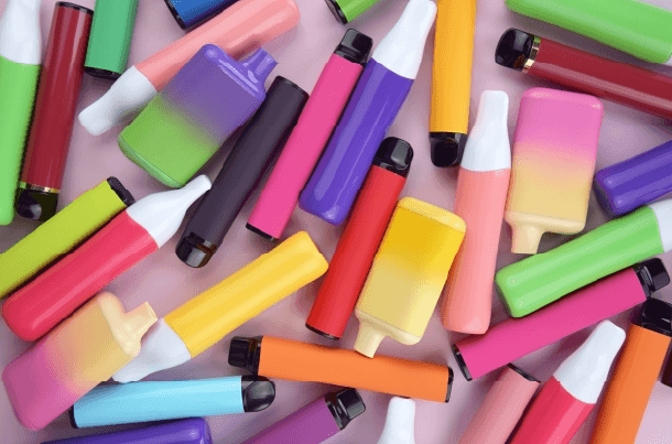 Colorful disposable vaping devices representing nicotine products that may affect life insurance eligibility and premium rates.