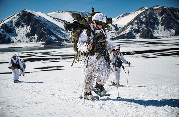 Soldiers from the 10th Mountain Division (LI) trek across snow-covered terrain during a winter training exercise, showcasing cold-weather readiness.