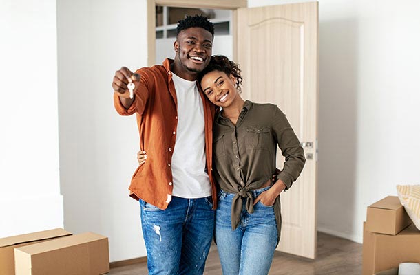 A military couple celebrates receiving the keys to their new home, underscoring the importance of protecting their future with life insurance.