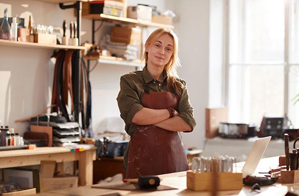 Veteran entrepreneur stands proudly in her workshop, symbolizing the independence and financial planning life insurance can help protect.
