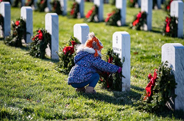 USBA honors Wreaths Across America Day &ndash; child at cemetery placing wreath